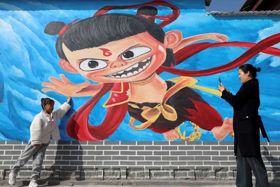 A girl who is presented with pictures with a wall painting that is characterized by a personality from 