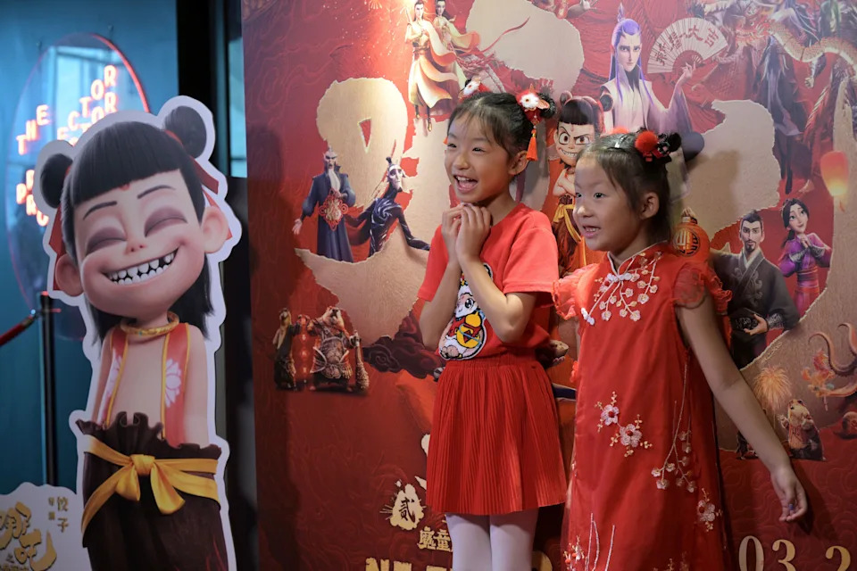 Children are raised for pictures in front of a poster during the first show 